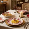 Servizio piatti Rose Rosse in porcellana con decorazione floreale rossa su tavola imbandita, perfetto per cene