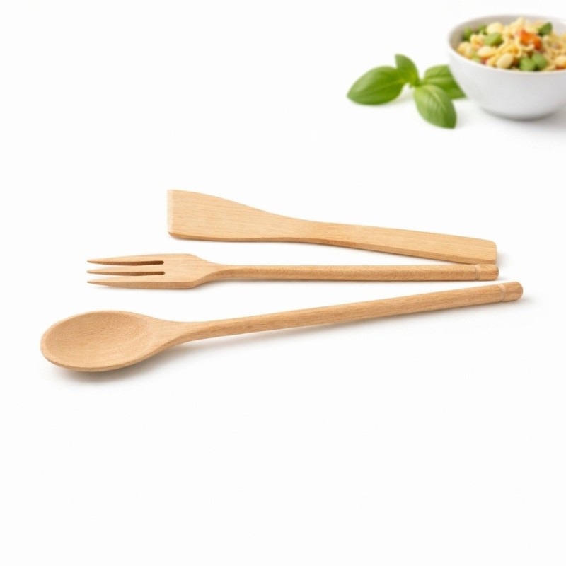 Tris di utensili da cucina in legno composto da cucchiaio lungo, forchetta e paletta su sfondo bianco